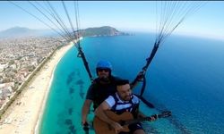 Antalya'da yamaç paraşütüyle atlayan psikolog gitar çalıp şarkı söyledi